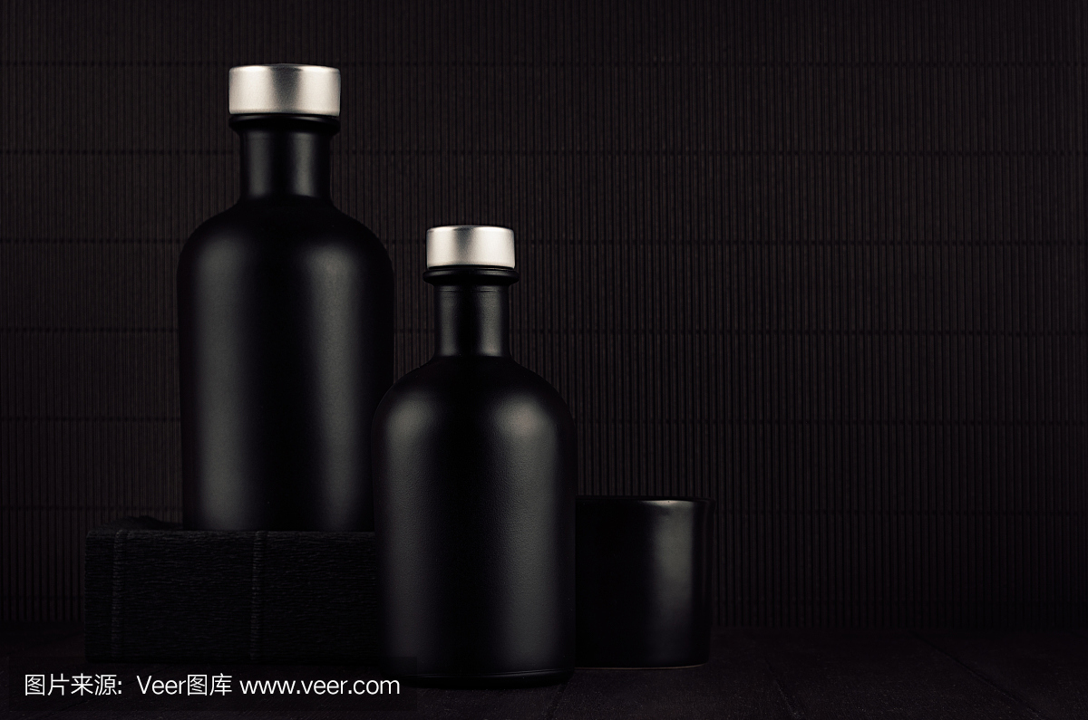 深黑色极简主义室内设计。空白黑色化妆品瓶在深色木板上,模拟。